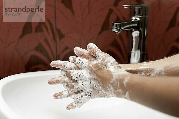 Seitenansicht einer Person beim Händewaschen mit fester Seife