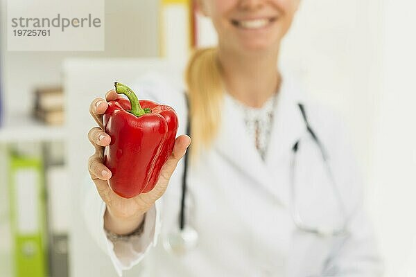 Nahaufnahme Arzt mit roter Paprika