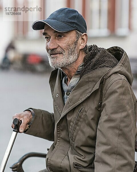 Seitenansicht Obdachloser Mann im Freien mit Gehstock
