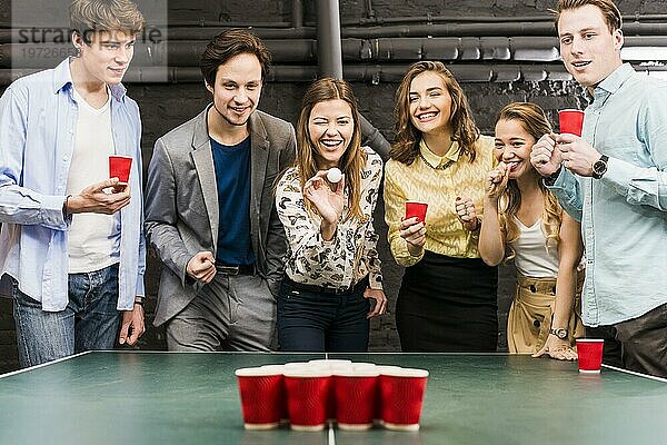 Gruppe glücklich lächelnde Freunde genießen Bier Pong Spiel Tisch Bar