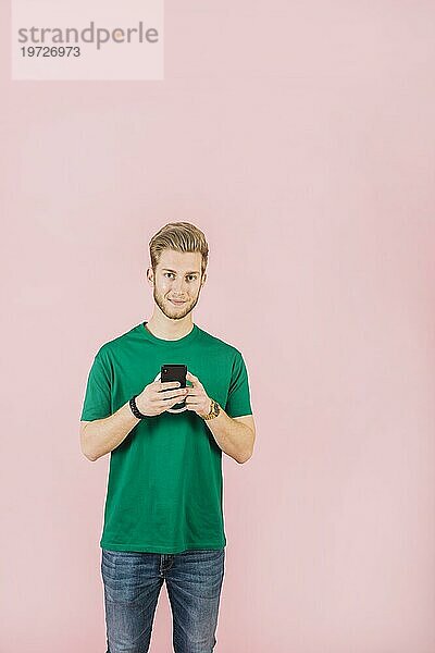 Porträt junger Mann mit Mobiltelefon und Kamera