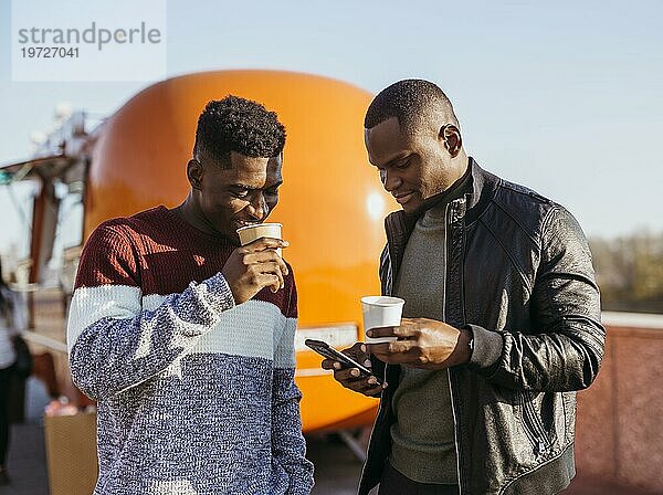 Mid shot Freunde genießen Kaffee vor Food Truck