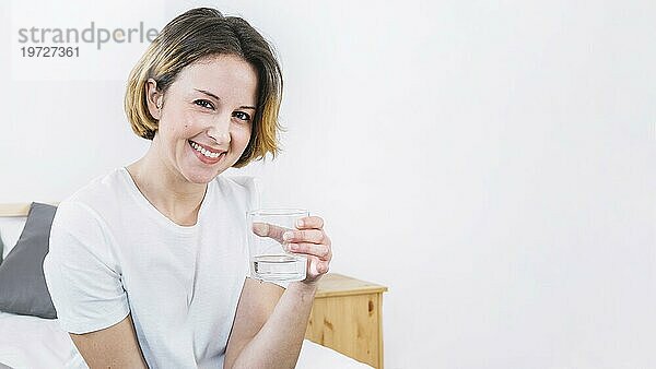 Frau hält Glas Wasser