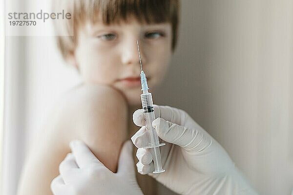 Arzt mit Handschuhen holt geimpftes Kind