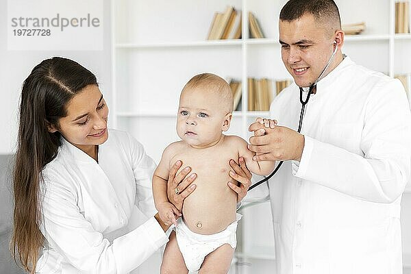 Frontansicht Ärzte halten bezauberndes Baby