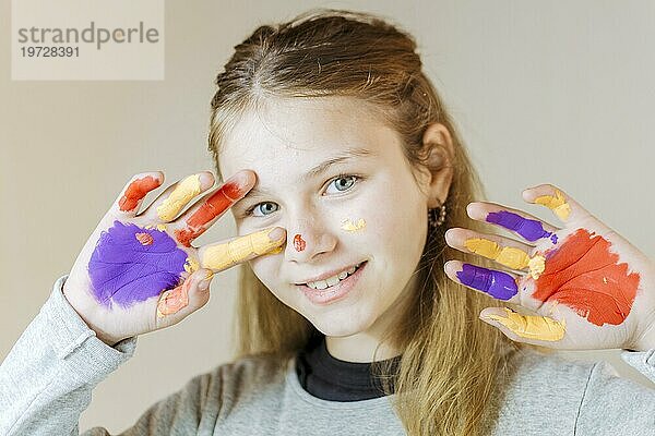 Glückliches Mädchen mit Händen gemalt Aquarellfarbe
