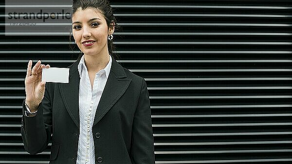 Zuversichtlich lächelnd Porträt lächelnd junge Geschäftsfrau zeigt weiße Visitenkarte