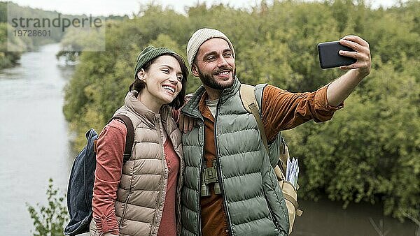 Glückliches Paar nimmt Selfie mit Smartphone Natur