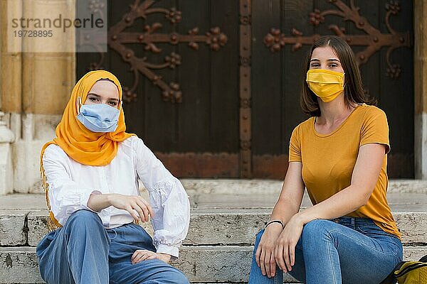 Vollbild Freunde mit medizinischen Masken