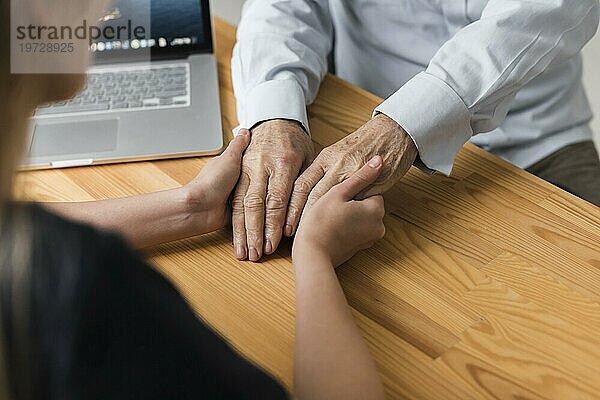 Krankenschwester hält Hände eines älteren Mannes Erleichterung