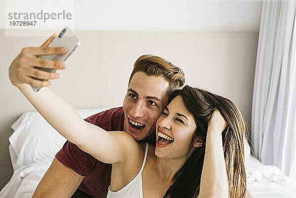 Glückliche Frau nimmt Selfie mit Mann