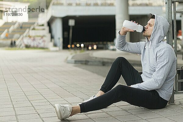 Erwachsene Männer  die im Freien Wasser trinken