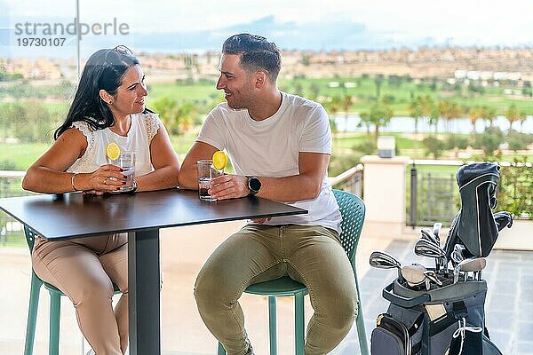 Glückliches Paar genießt einen Cocktail in einem Restaurant eines Golfclubs