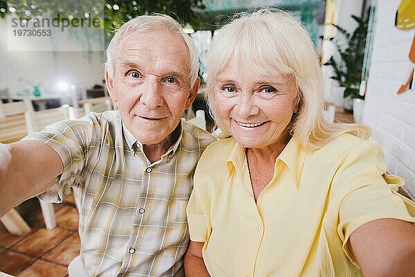 Erfreut Senior Paar umarmt sitzen Café schießen selfie