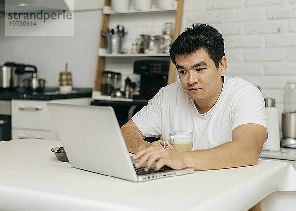 Mann zu Hause während der Pandemie mit Laptop