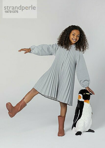 Voller Schuss glückliches Mädchen posiert mit Pinguin