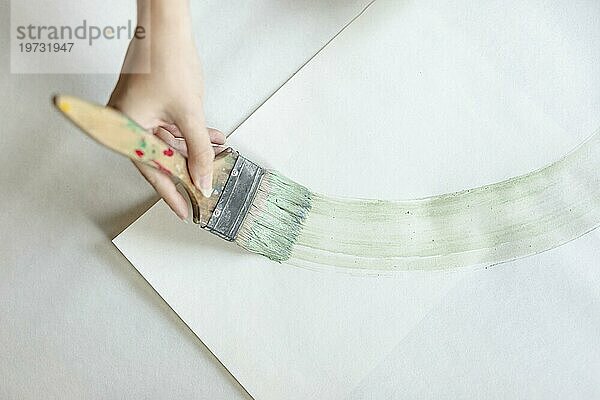 Draufsicht Frau malt mit großem Pinsel