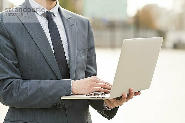 Geschäftsmann benutzt Laptop im Freien