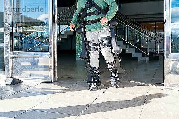 Mechanisches Exoskelett  behinderte Person  die mit Hilfe eines Roboterskeletts geht  Physiotherapie in einem modernen Krankenhaus  futuristische Physiotherapie