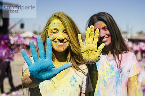 Close up zwei junge Frauen zeigen ihre Hände mit Holi Farbe gemalt