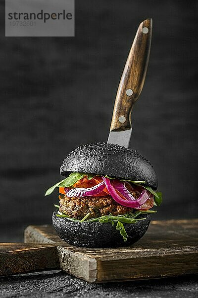 Vorderansicht Veggie Burger mit schwarzen Brötchen Schneidebrett mit Messer