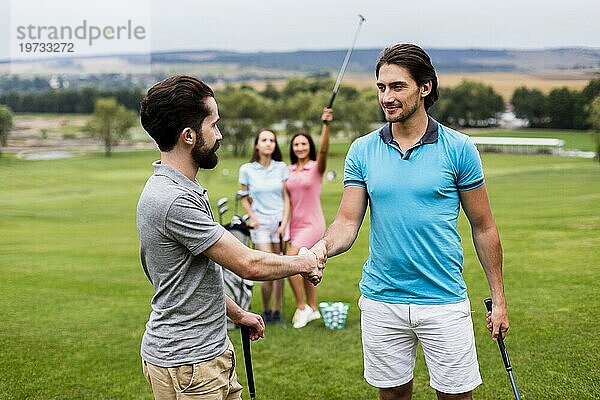 Golf Freunde schütteln sich die Hände Golfplatz