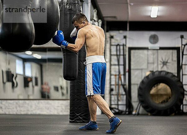 Seitenansicht männlicher Boxer beim Training mit Schutzhandschuhen