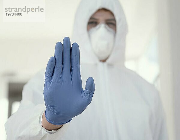 Person mit medizinischer Maske  die eine Schutzausrüstung gegen biologische Gefahren trägt