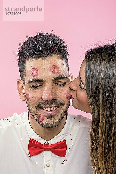 Frau küsst Mann mit Lippenstift Kussmarken Wange
