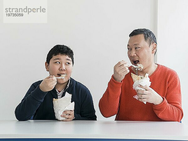 Asiatischer Vater und Sohn essen Fast Food