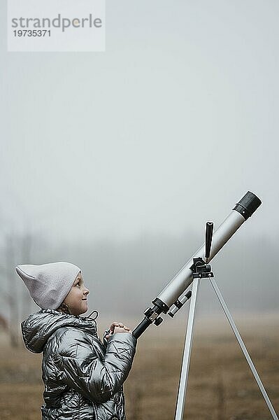 Seitenansicht kleines Mädchen mit Teleskop