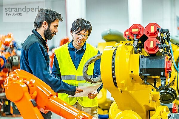 Ein internationales Team von Ingenieuren informiert sich in einer Industrie für Roboterarme