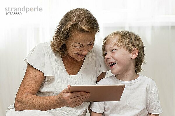 Glückliches Kind Oma mit Tablette
