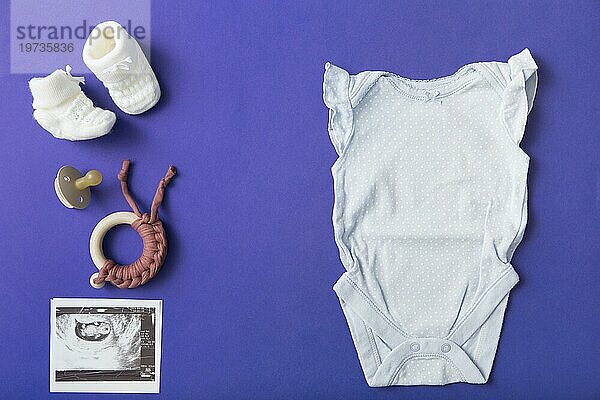 Pair Baby Wollschuhe Schnuller Spielzeug Baby Onesie Ultraschall Bild blauem Hintergrund