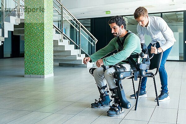 Mechanisches Exoskelett  Physiotherapeutin hilft behinderter Person mit Roboterskelett aufzustehen  Physiotherapie in einem modernen Krankenhaus: