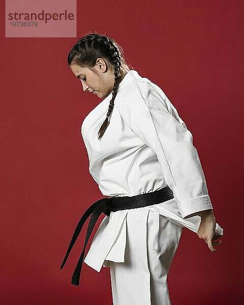 Sideways Karate Frau traditionellen weißen Kimono roten Hintergrund