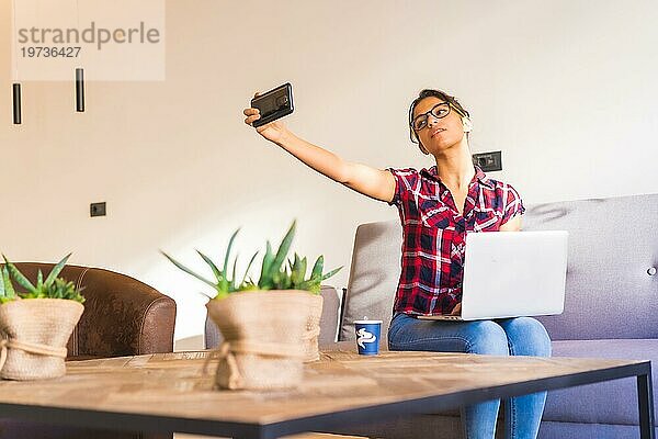 Horizontales Foto mit Kopierbereich einer Frau  die ein Selfie macht  während sie zu Hause arbeitet