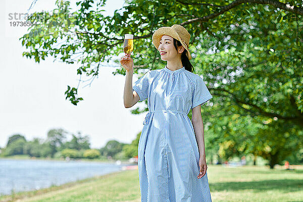 Junge Japanerin genießt draußen ein kühles Bier