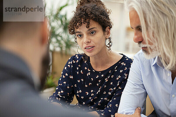 Erwachsene Frau diskutiert während des Treffens mit Partner und Anwalt