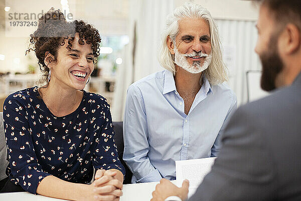 Erwachsenes Paar lächelt während eines Treffens mit einem Anwalt