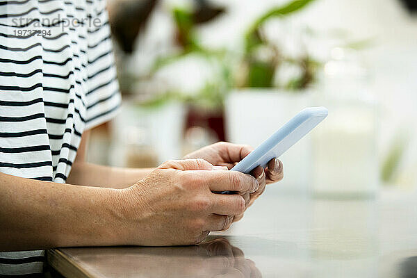 Nahaufnahme der Hände einer erwachsenen Frau  während sie ihr Smartphone benutzt