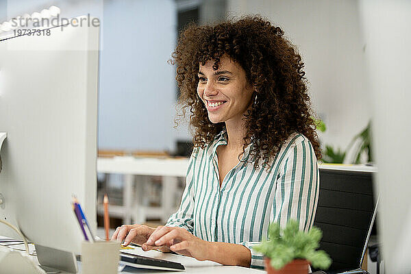 Young adult businesswoman using computer at office