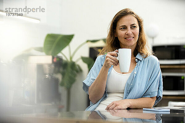 Female entrepreneur having a coffee break at office