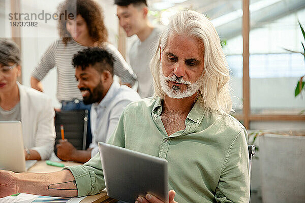 Industriedesigner nutzt digitales Tablet während eines Meetings