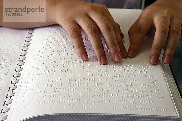 Close up on hands of blind girl reading braille book  Center for Blind Children  Ho Chi Minh City  Vietnam  Indochina  Southeast Asia  Asia