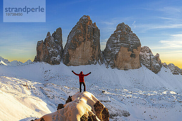 Glücklicher Wanderer genießt den Blick auf die Drei Zinnen bei Sonnenuntergang  Winterblick  Drei Zinnen  Sexten  Dolomiten  Südtirol  Italien  Europa