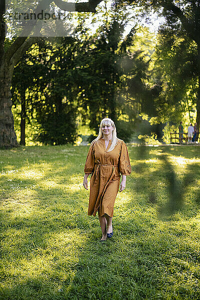 Lächelnde Frau  die im Park auf Gras läuft