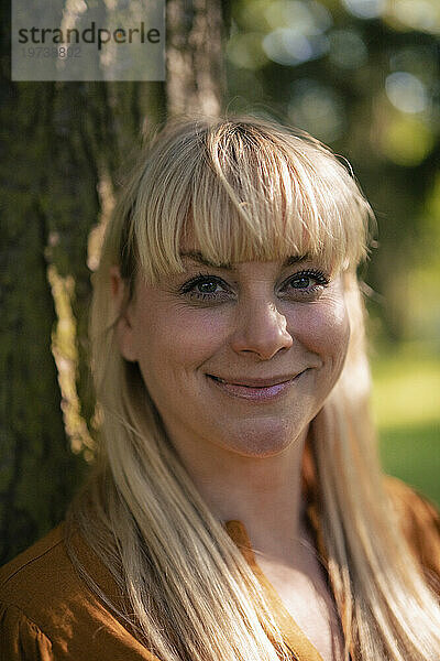 Lächelnde blonde Frau im Park