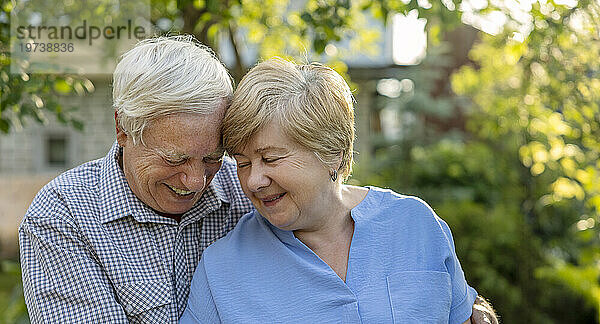 Smiling elderly couple enjoying leisure time in garden