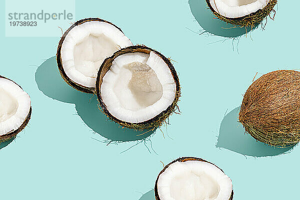 Halbierte frische Kokosnüsse vor blauem Hintergrund